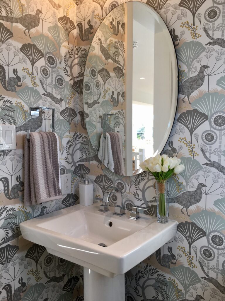 Washroom decorated in light grey color with whimsical wallpaper